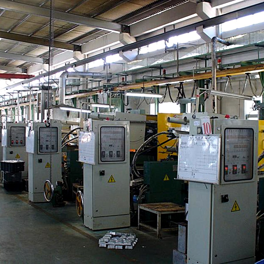 Row of die casting machines with ingots stacked on the floor